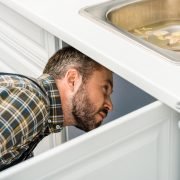 man doing property inspection report in kitchen